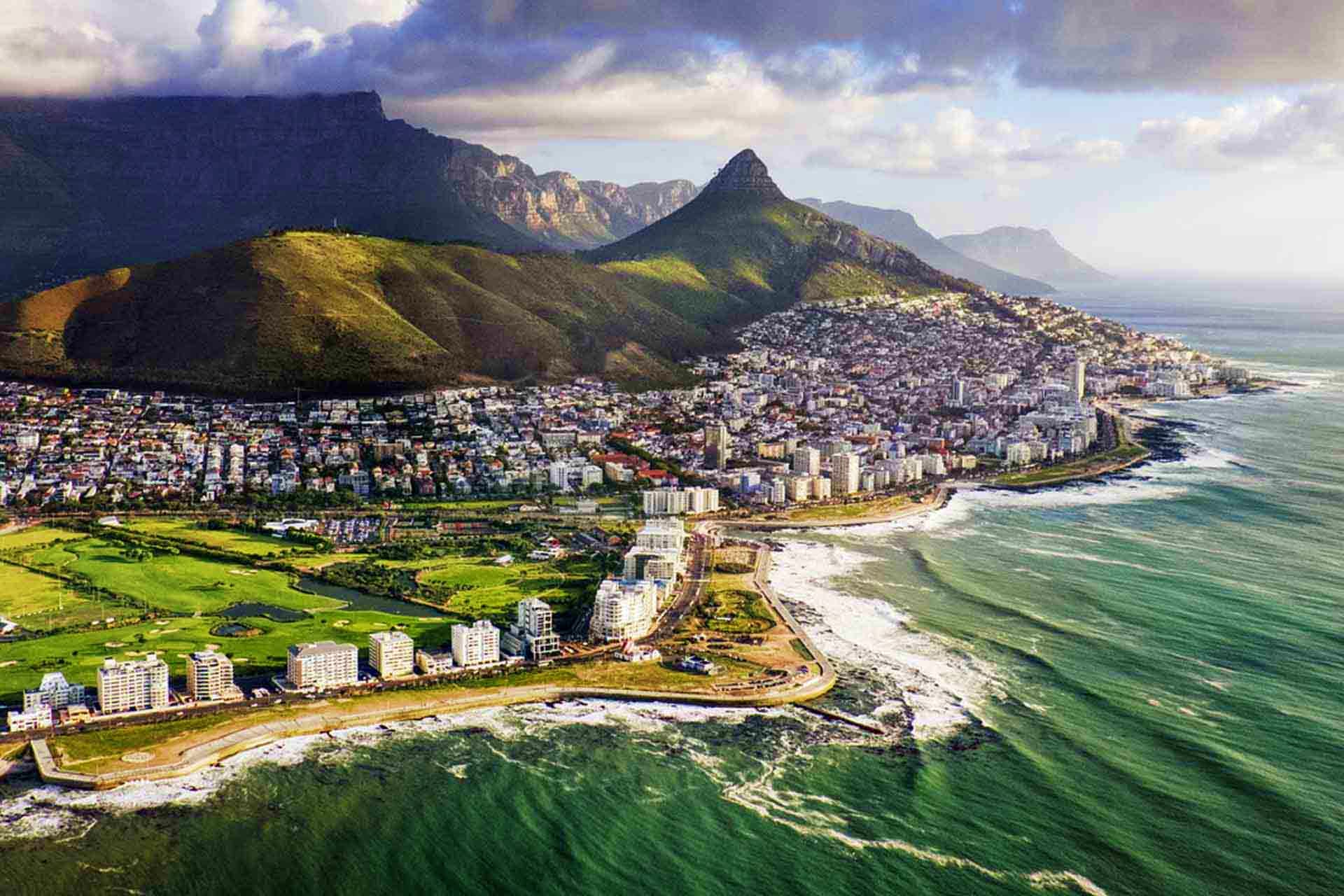 Aerial view of Cape Town's coastline with Table Mountain, Signal Hill, and the Twelve Apostles mountain range overlooking the